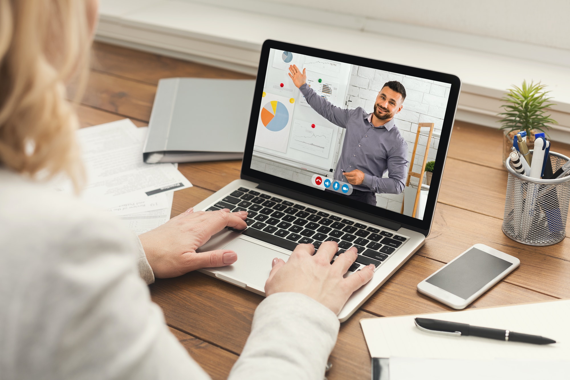 Businesswoman Having Online Meeting With Coworker Sitting At Laptop Indoor